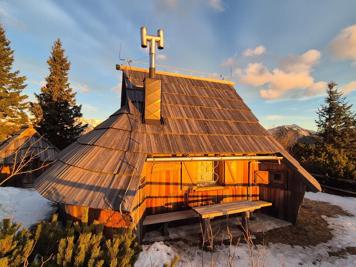 Koča Kamrica und ihre Terrasse in natürlicher Umgebung